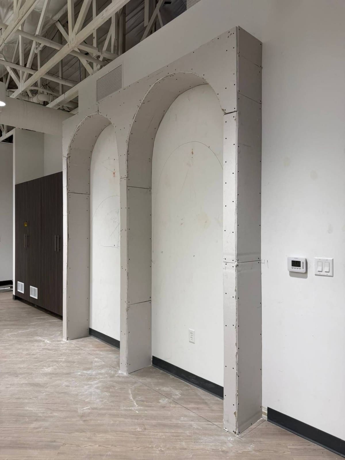 Two arched wall niches framed and covered in drywall, before finishing